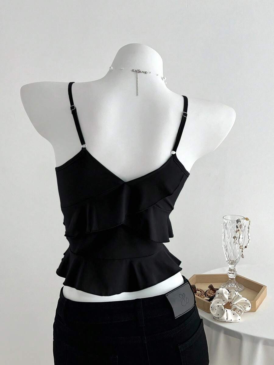 Women's solid color camisole top with thin spaghetti straps, tiered layers, and a flared ruffled hem.