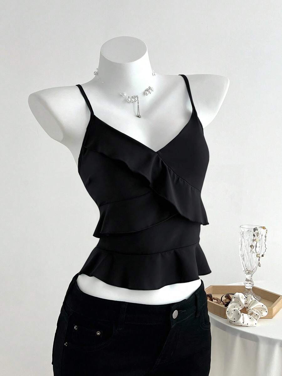 Women's solid color camisole top with thin spaghetti straps, tiered layers, and a flared ruffled hem.