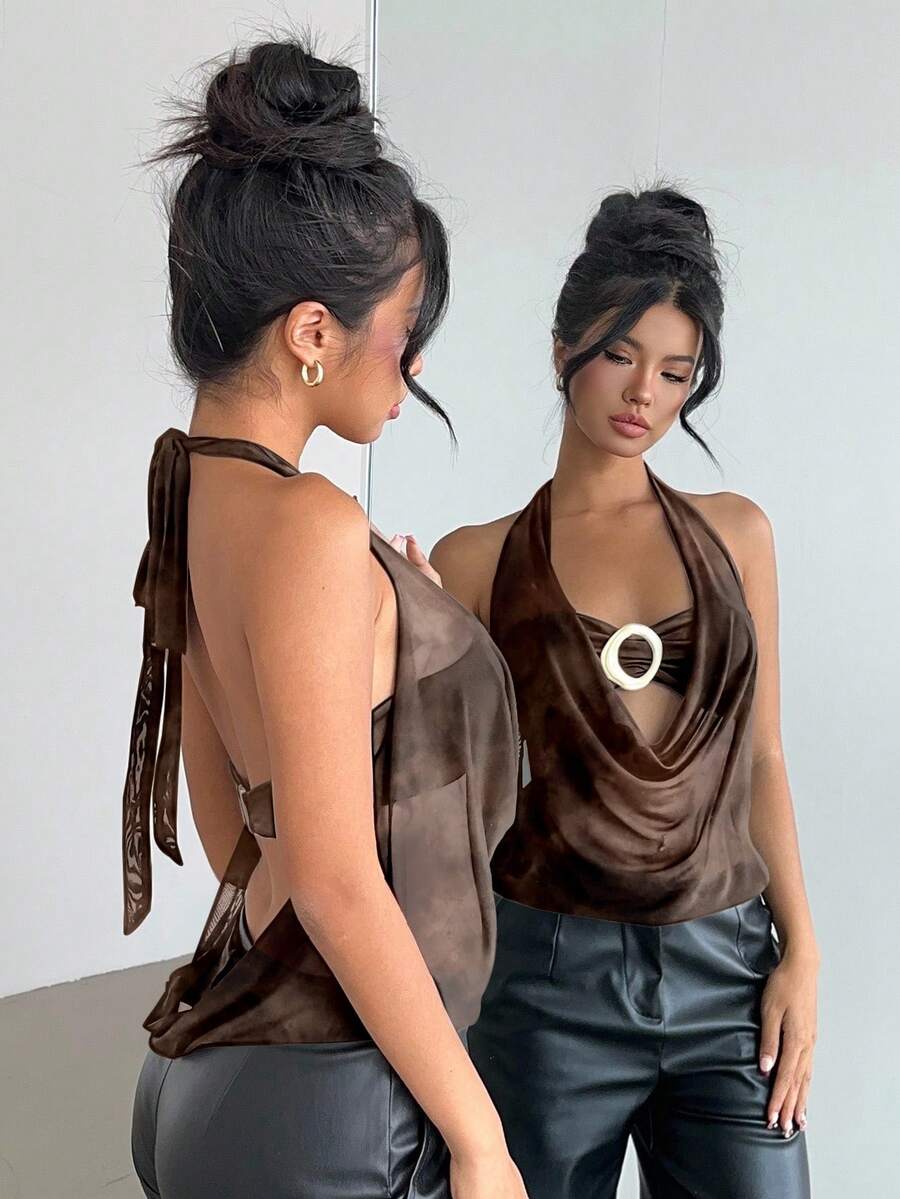 Brown and white polka dot semi-sheer halter camisole top with a plunging neckline, backless design, draped front, and metallic studded embellishments.