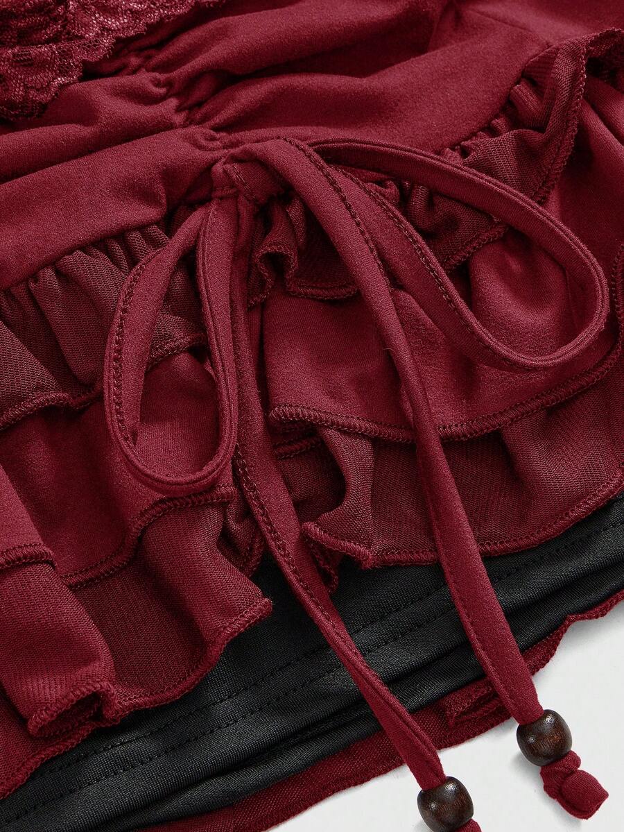 Women's black low-waist mini skirt with drawstring tie, ruched details, lace trim, layered ruffle hem, and asymmetric styling