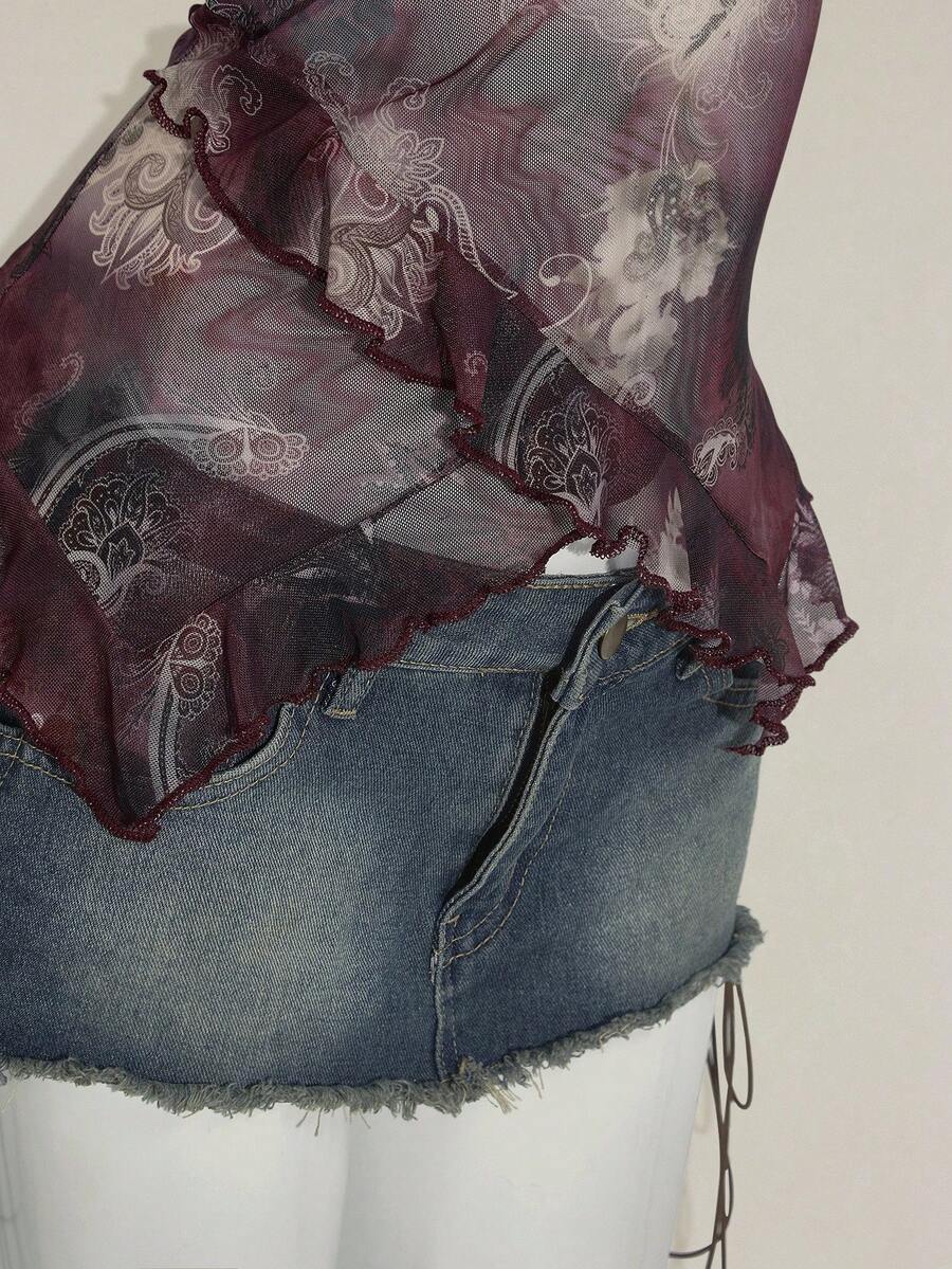 Women's graphic print camisole top featuring thin spaghetti straps, a backless cut, and an asymmetrical hem.