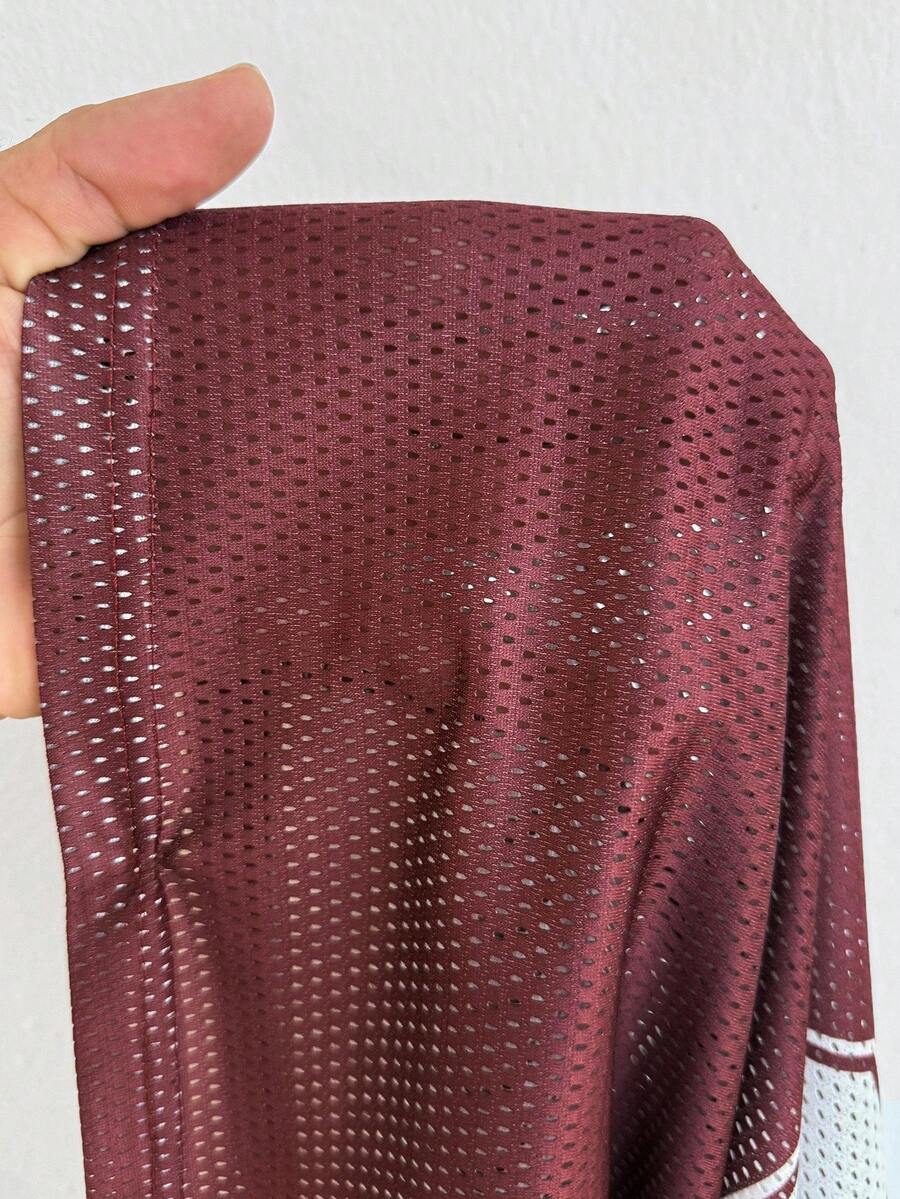 Women's oversized mesh jersey t-shirt with sporty number print, short drop-shoulder sleeves, and V-neckline.
