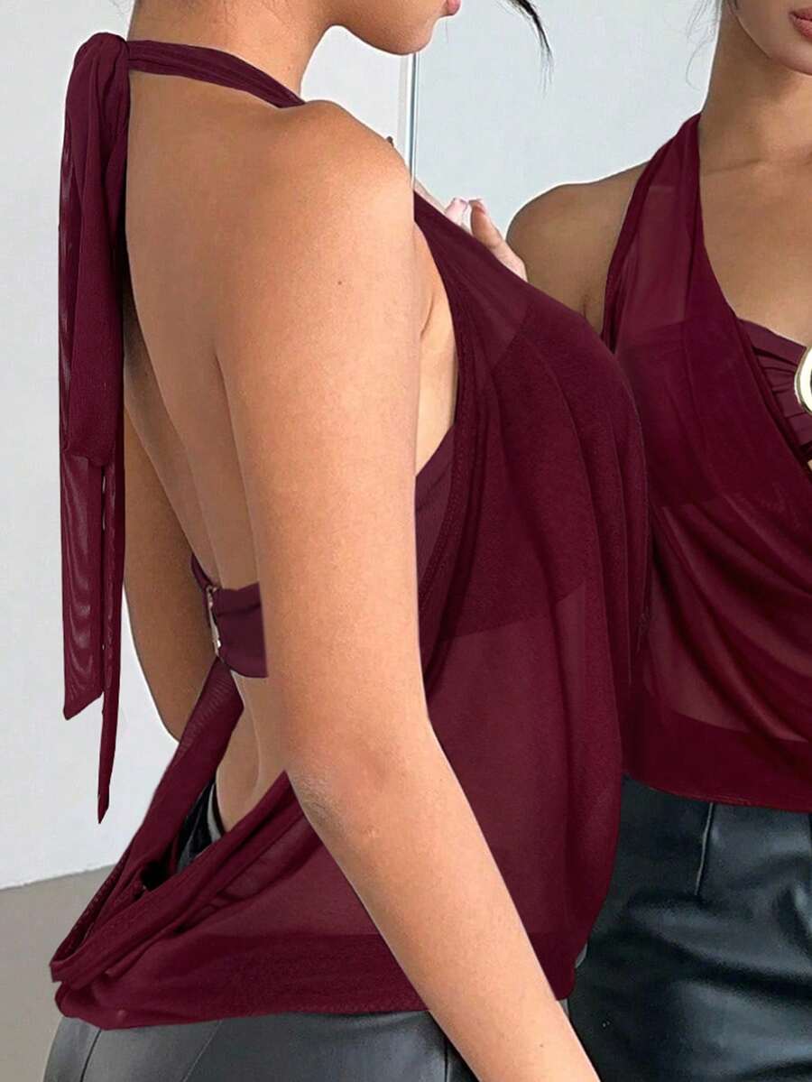 Brown and white polka dot semi-sheer halter camisole top with a plunging neckline, backless design, draped front, and metallic studded embellishments.