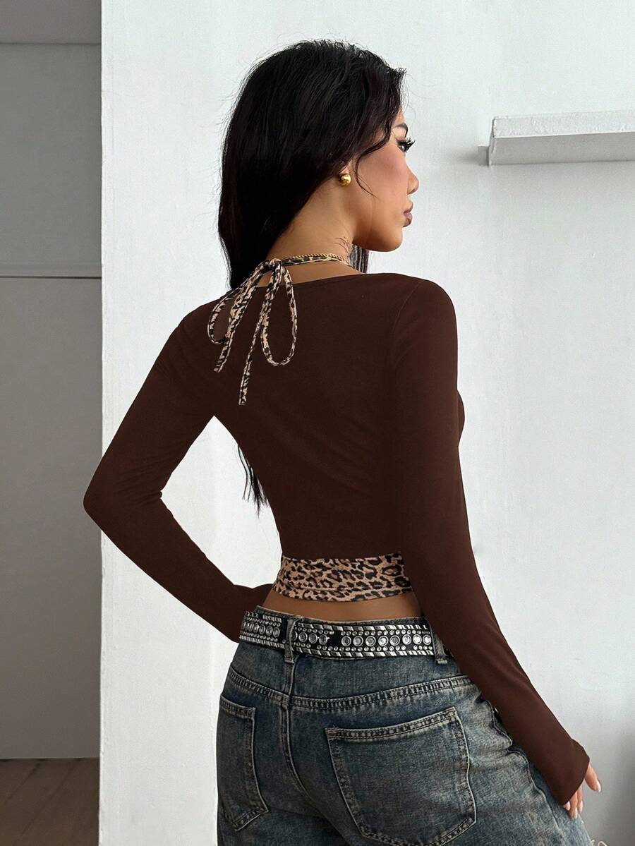 Women's black and white cropped Y2K-style top with lace-up camisole look, halter neckline, long sleeves, button front, rib-knit texture, and slim fit
