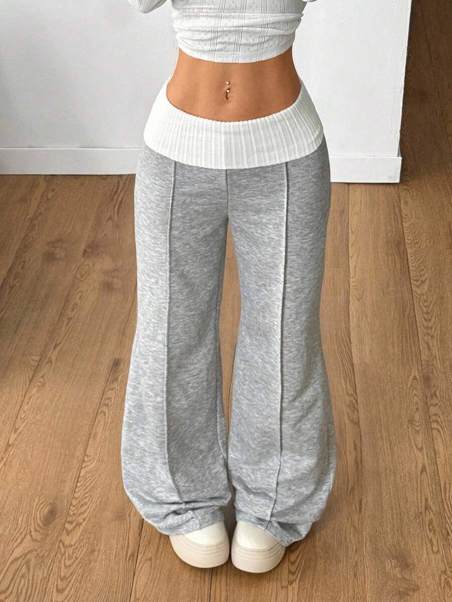 Women's wide leg flare sweatpants featuring a black and white colorblock contrast fold waistband and side stripe details.