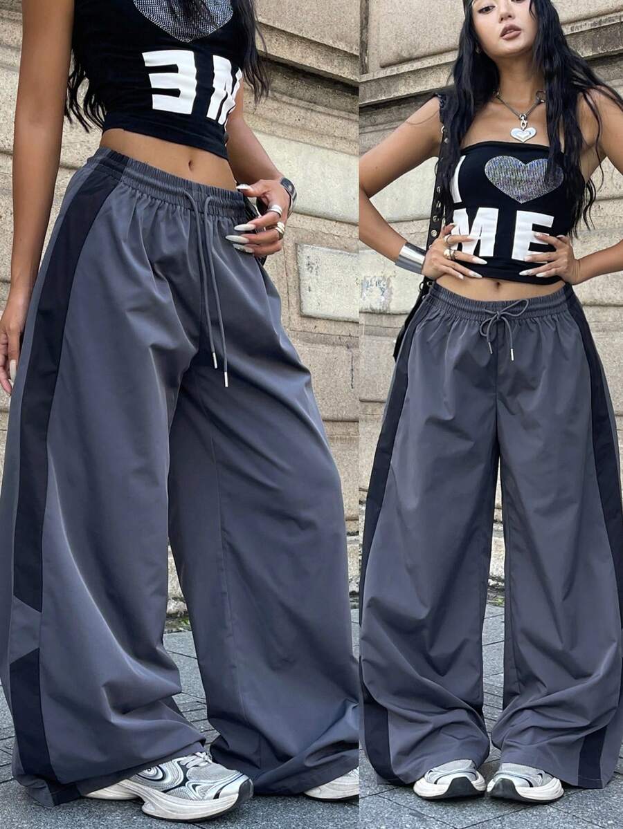 Women's plus size loose straight leg pants featuring a black and white color block design with side stripes and an elastic drawstring waist.