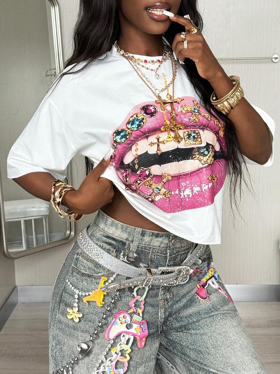 Front view of a women's black oversized crop t-shirt with pink lips graphic, round neckline, and short drop-shoulder sleeves.