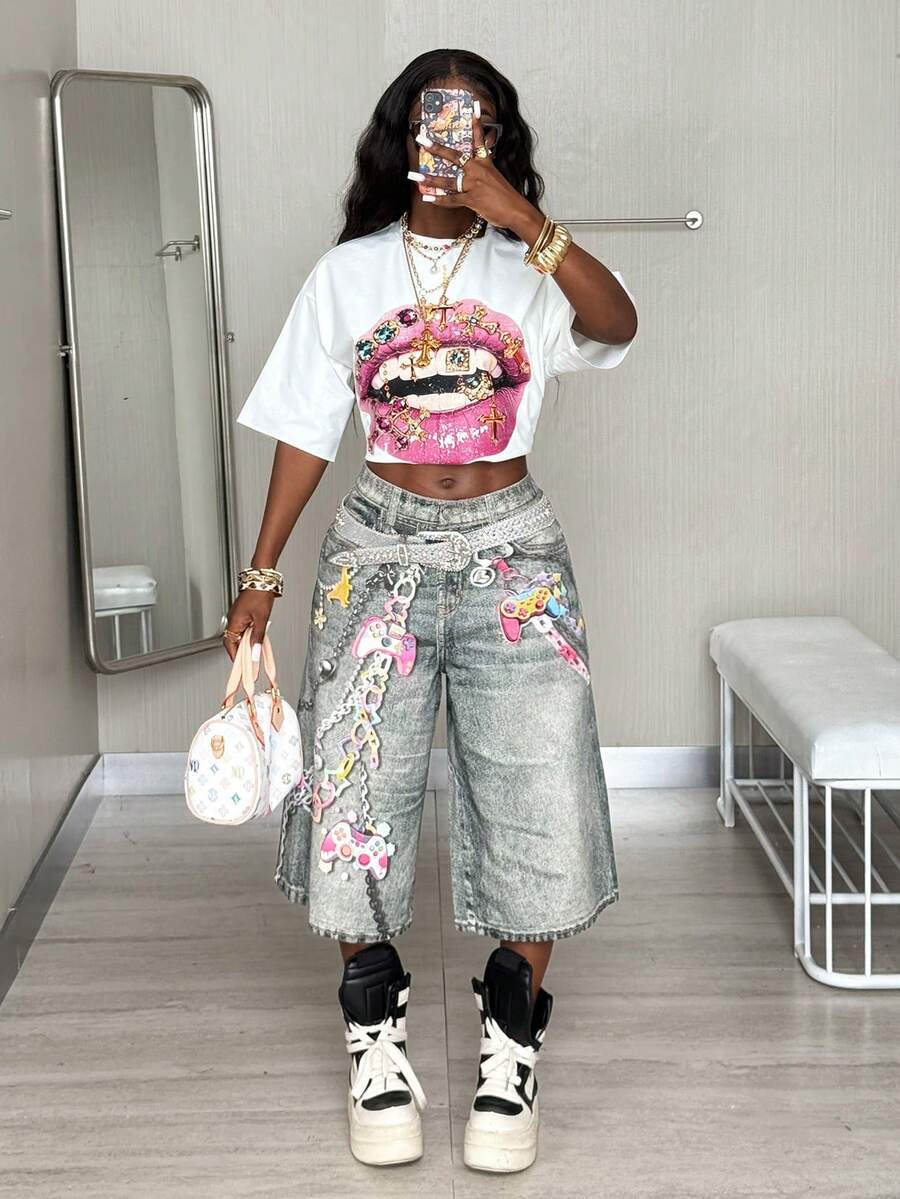 Front view of a women's black oversized crop t-shirt with pink lips graphic, round neckline, and short drop-shoulder sleeves.