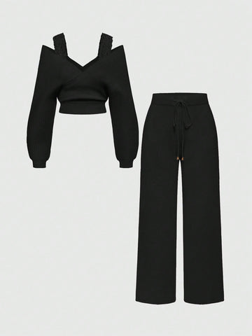 Women's two-piece rib-knit sweater set featuring a long-sleeve cold-shoulder crop top with strap details and matching wide-leg pants.