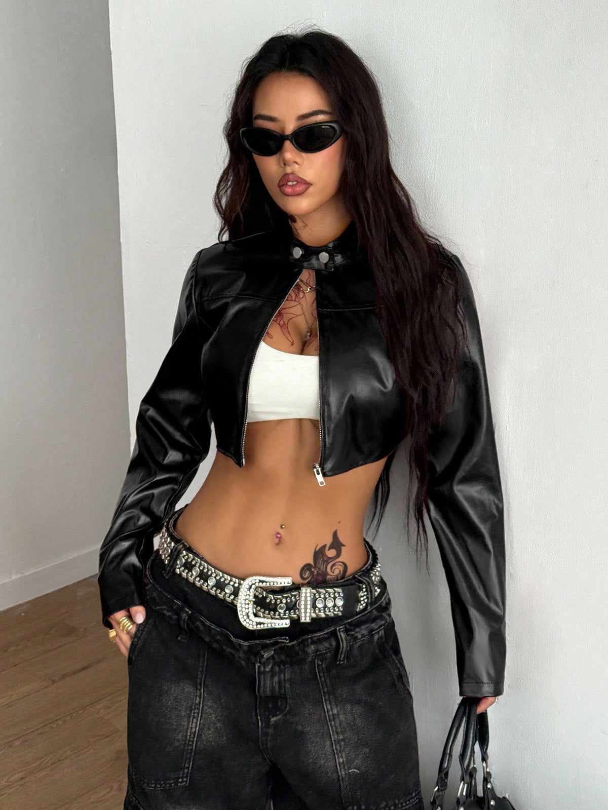Front view of a women's black cropped PU leather jacket featuring a stand collar, long sleeves, and front zipper closure.