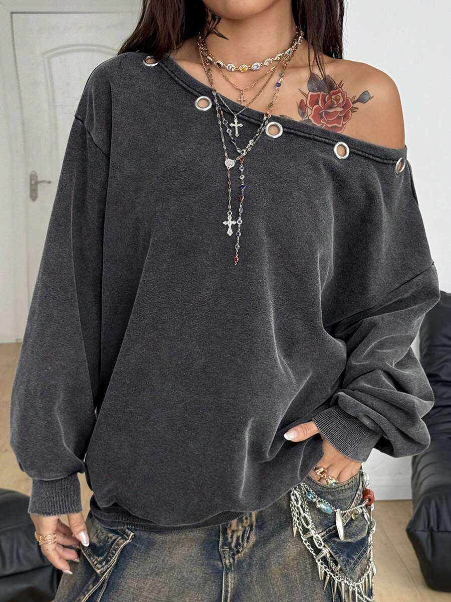 Women's oversized dark grey long sleeve sweatshirt featuring an asymmetrical boat neckline with grommet eyelet details and drop shoulders.