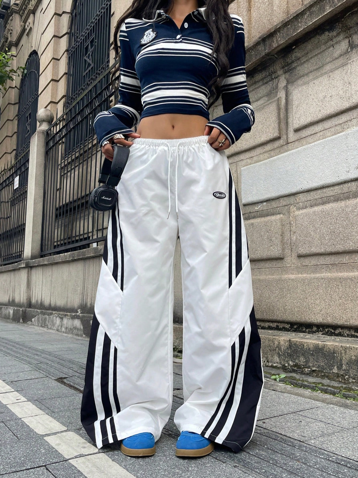 Women's wide leg parachute pants featuring an army green color-blocked design with side stripes and an adjustable drawstring waist.