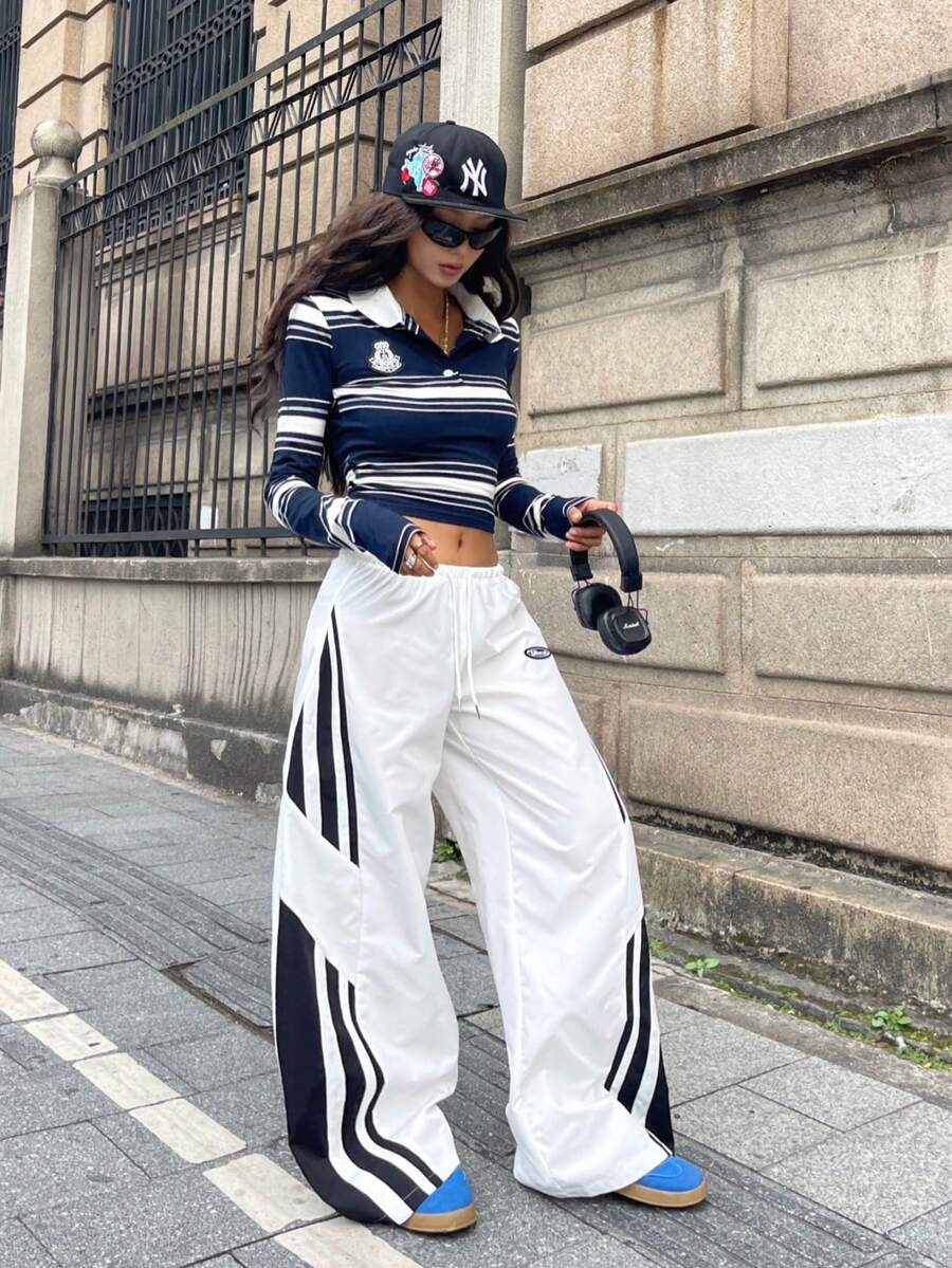 Women's wide leg parachute pants featuring an army green color-blocked design with side stripes and an adjustable drawstring waist.