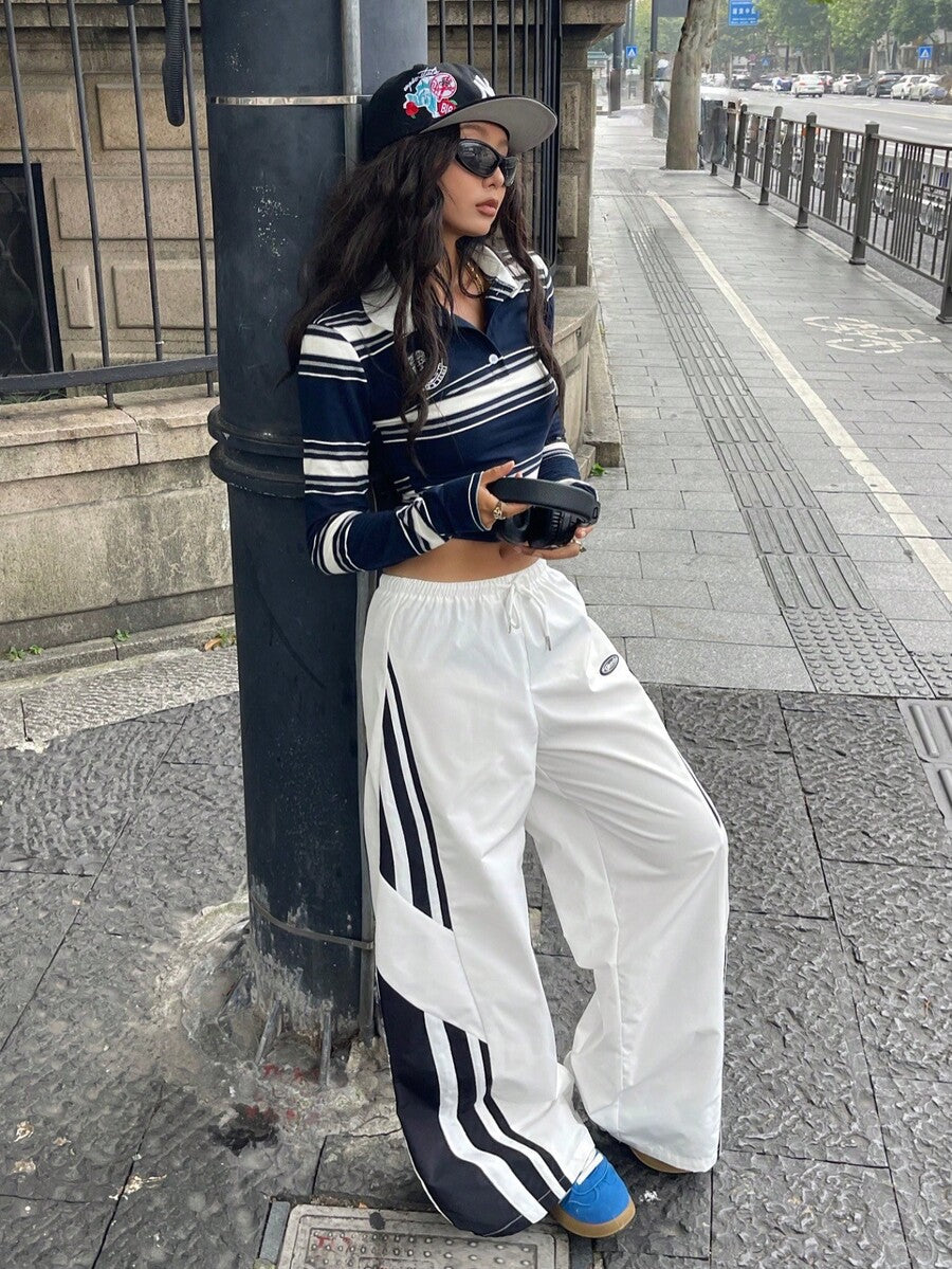 Women's wide leg parachute pants featuring an army green color-blocked design with side stripes and an adjustable drawstring waist.