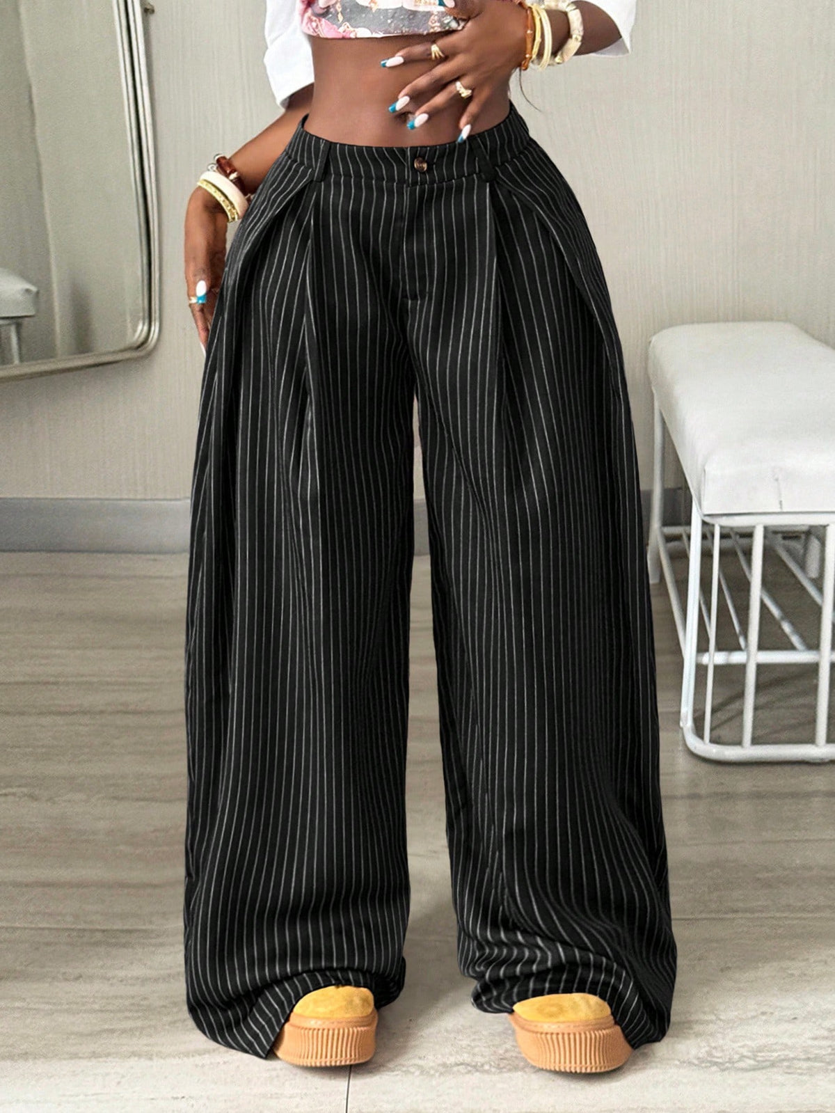 Women's brown striped wide leg pants with a low waist, curved hem, and loose casual fit in woven fabric.