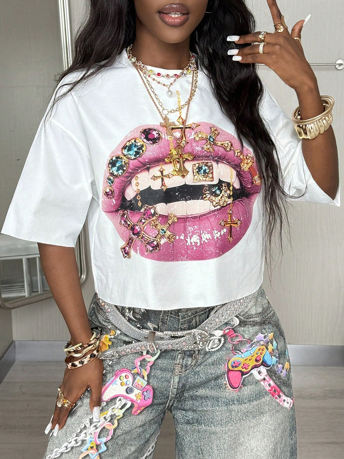 Front view of a women's black oversized crop t-shirt with pink lips graphic, round neckline, and short drop-shoulder sleeves.