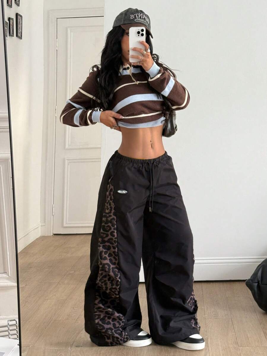 Women's black baggy jogger pants with an adjustable drawstring waist and colorblock polka dot geometric pattern.