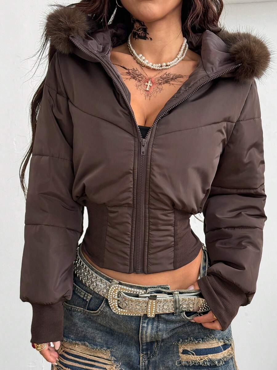 Women's brown cropped puffer jacket featuring a faux fur trimmed hood, front zipper, and ribbed hem.