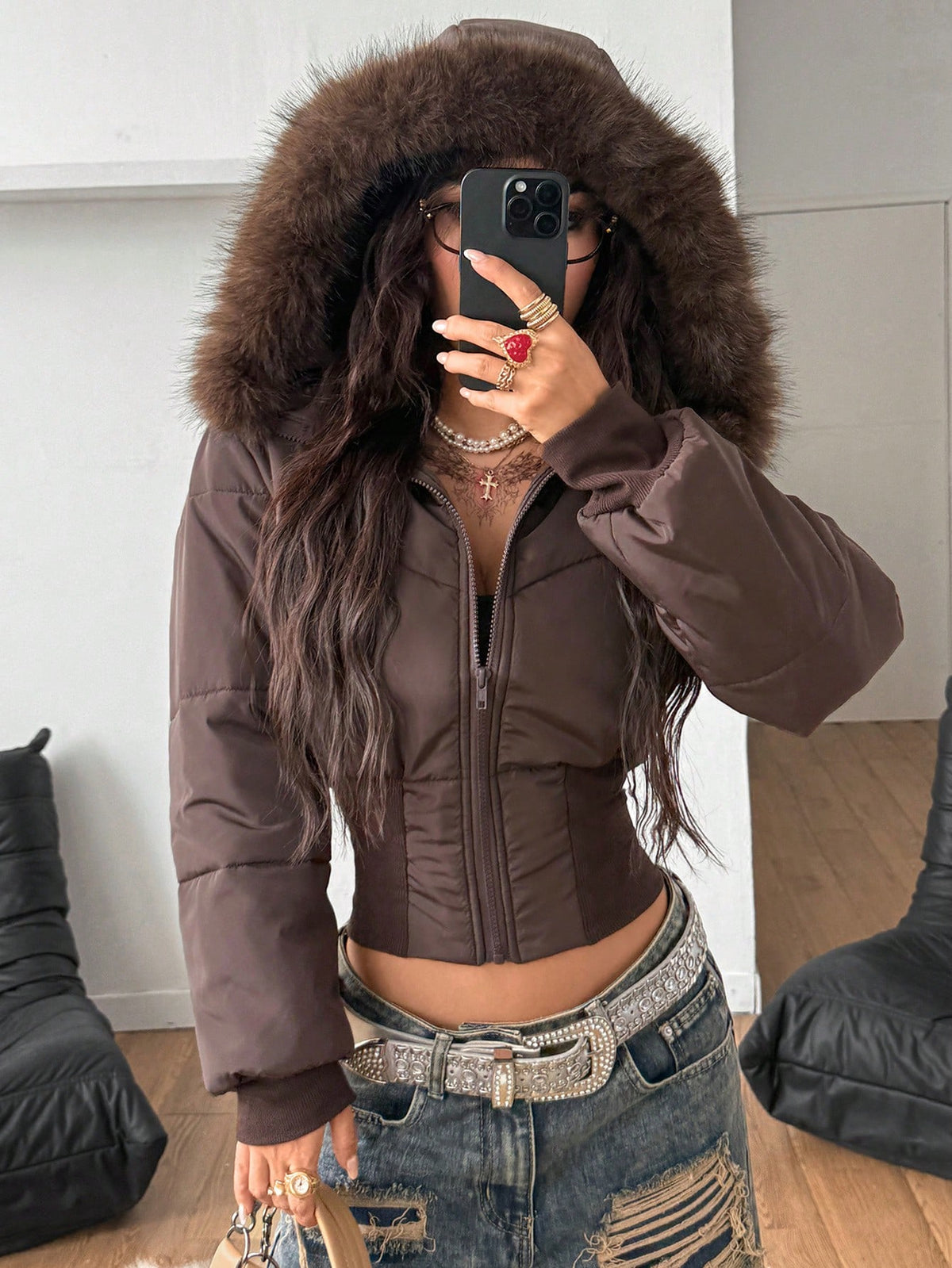 Women's brown cropped puffer jacket featuring a faux fur trimmed hood, front zipper, and ribbed hem.
