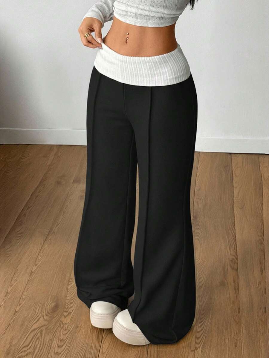 Women's wide leg flare sweatpants featuring a black and white colorblock contrast fold waistband and side stripe details.
