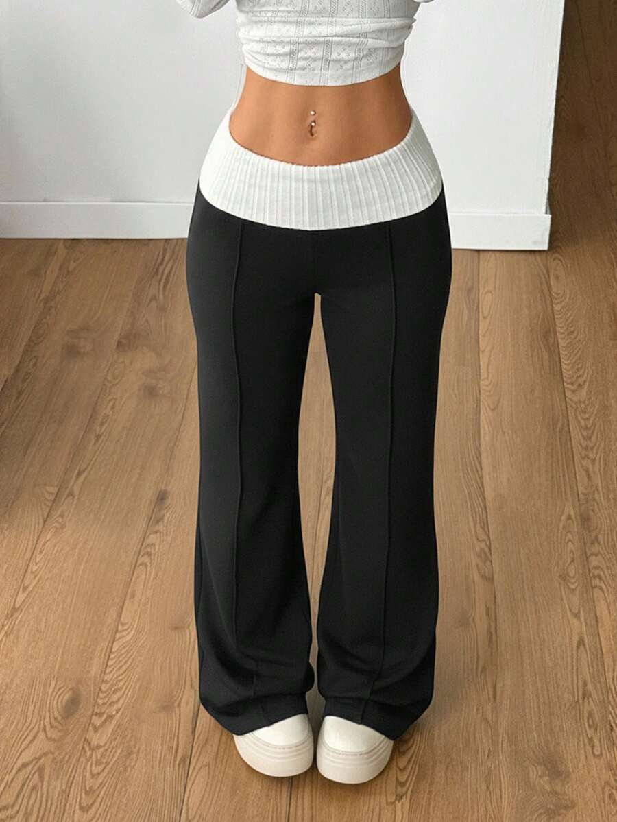 Women's wide leg flare sweatpants featuring a black and white colorblock contrast fold waistband and side stripe details.