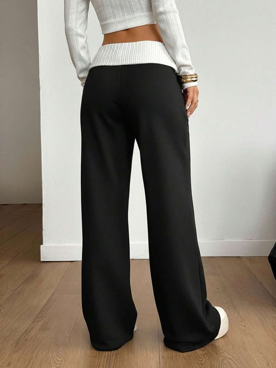 Women's wide leg flare sweatpants featuring a black and white colorblock contrast fold waistband and side stripe details.