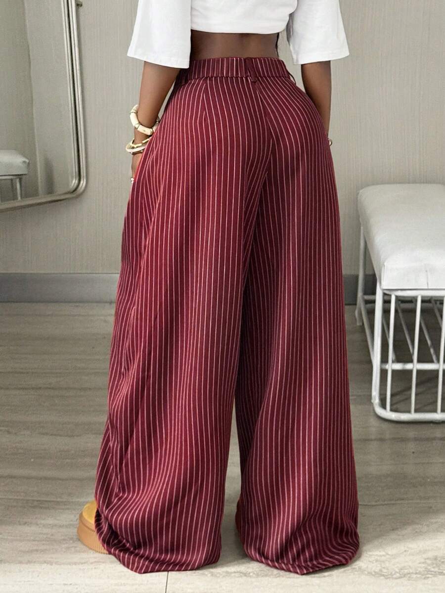 Women's brown striped wide leg pants with a low waist, curved hem, and loose casual fit in woven fabric.