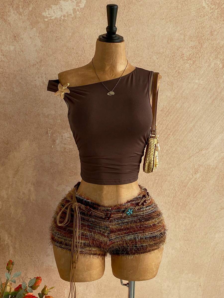 Women's black fuzzy knit two-piece set with an asymmetrical crop camisole top featuring ruched detail and cutout back, paired with matching mini shorts.