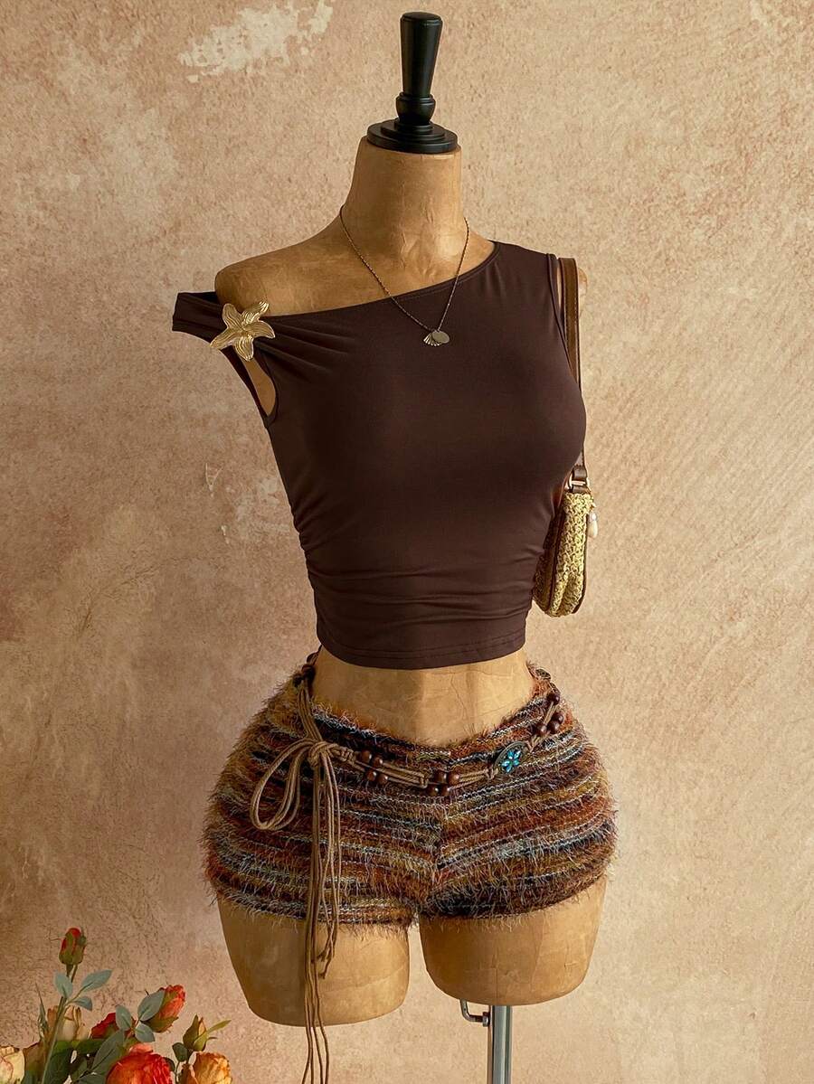 Women's black fuzzy knit two-piece set with an asymmetrical crop camisole top featuring ruched detail and cutout back, paired with matching mini shorts.
