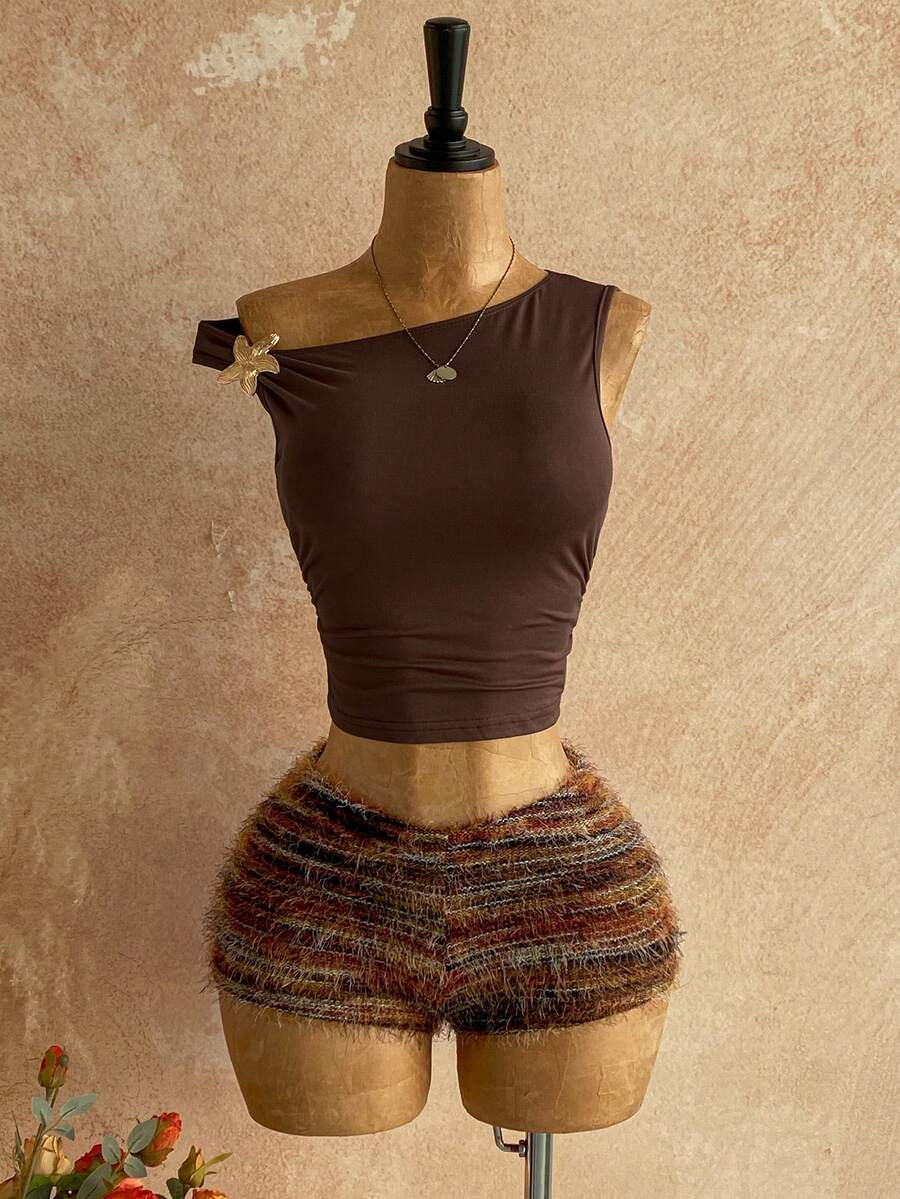 Women's black fuzzy knit two-piece set with an asymmetrical crop camisole top featuring ruched detail and cutout back, paired with matching mini shorts.