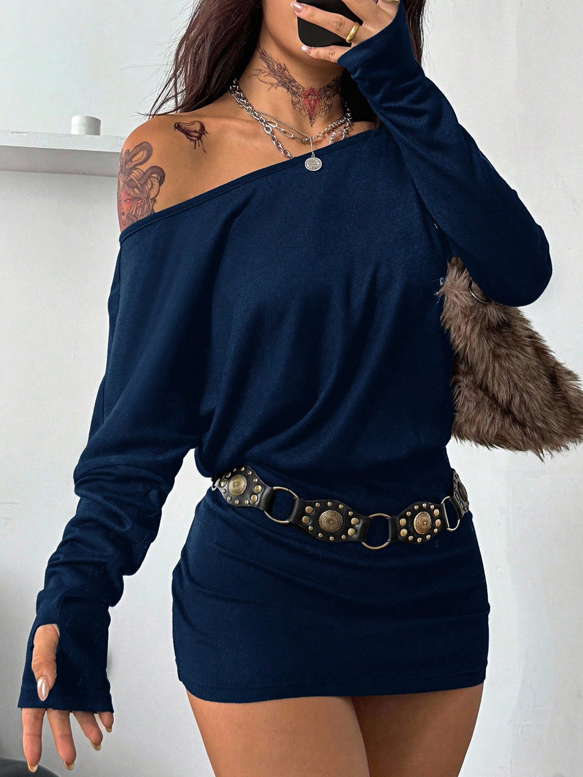 Women's long sleeve bodycon mini dress in black knitted fabric with an asymmetrical neckline and ruched accents.