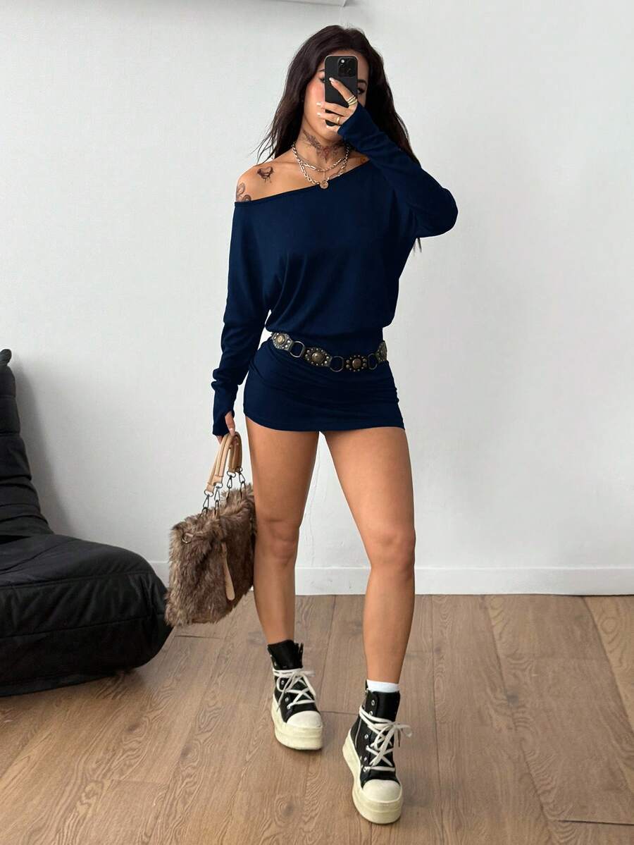 Women's long sleeve bodycon mini dress in black knitted fabric with an asymmetrical neckline and ruched accents.