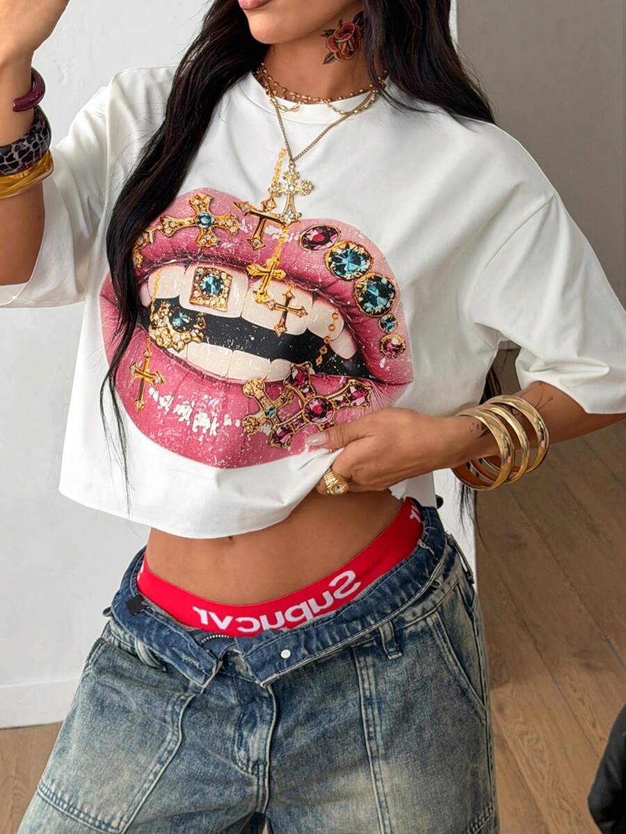 Front view of a women's black oversized crop t-shirt with pink lips graphic, round neckline, and short drop-shoulder sleeves.