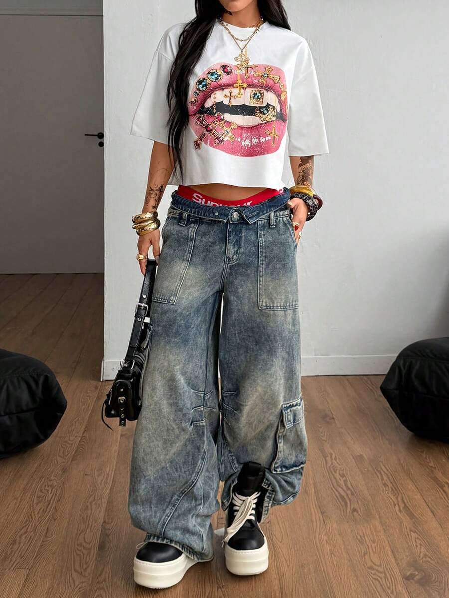 Front view of a women's black oversized crop t-shirt with pink lips graphic, round neckline, and short drop-shoulder sleeves.