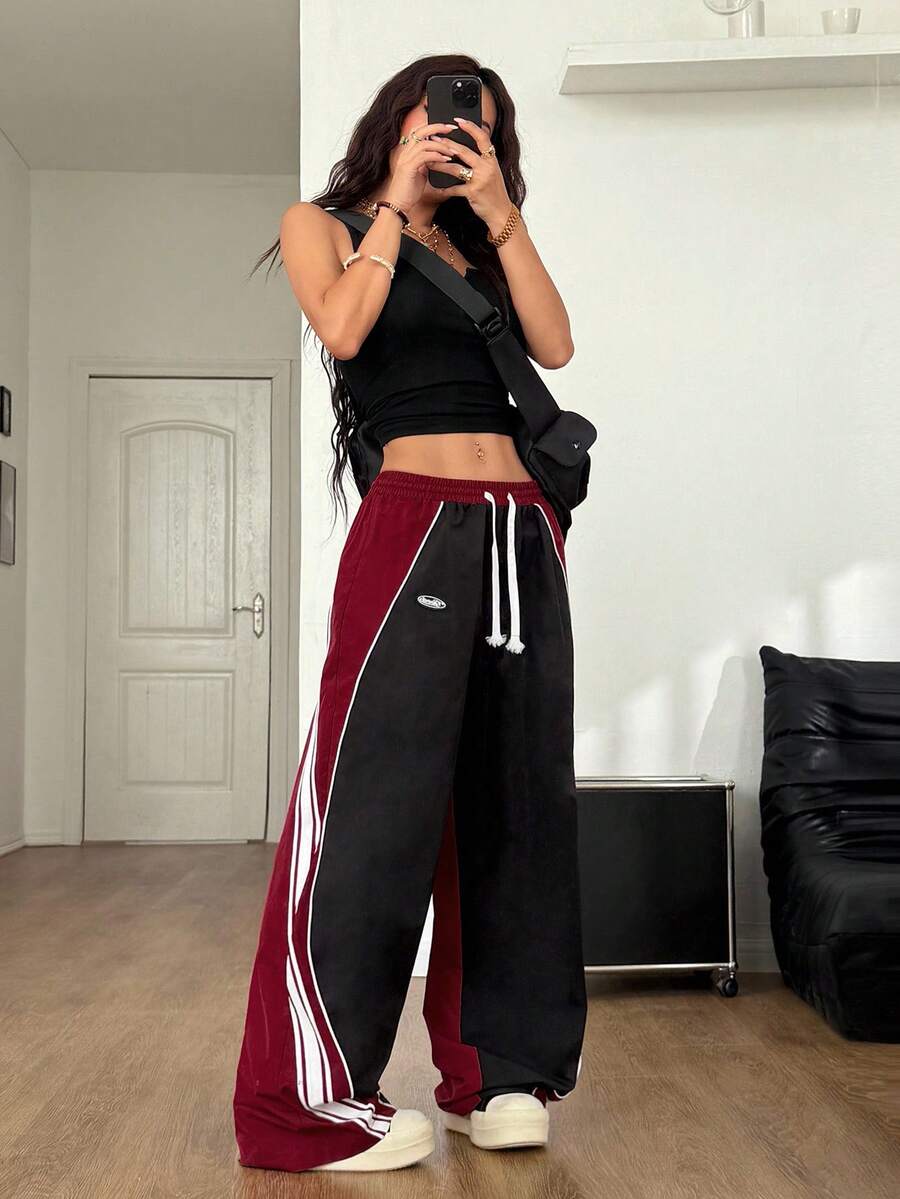 Women's loose fit straight leg pants in black and white with banded texture design, low drawstring waist, and pockets.