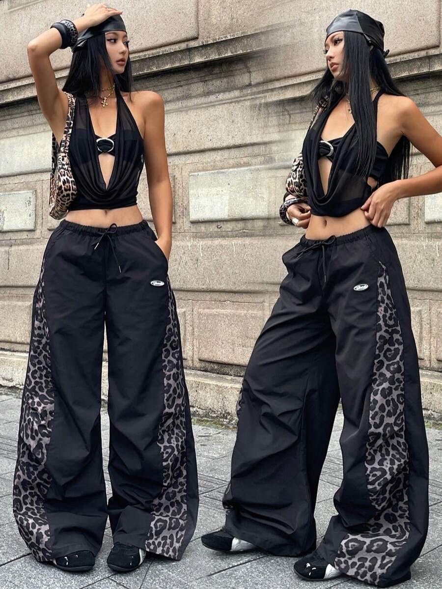 Women's black baggy jogger pants with an adjustable drawstring waist and colorblock polka dot geometric pattern.