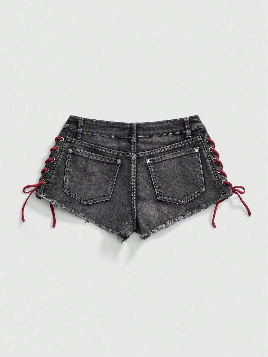 Women's Y2K low waist camo mini skort shorts featuring lace-up knot details, grommet eyelets, graphic lettering pattern, and a zipper fly.