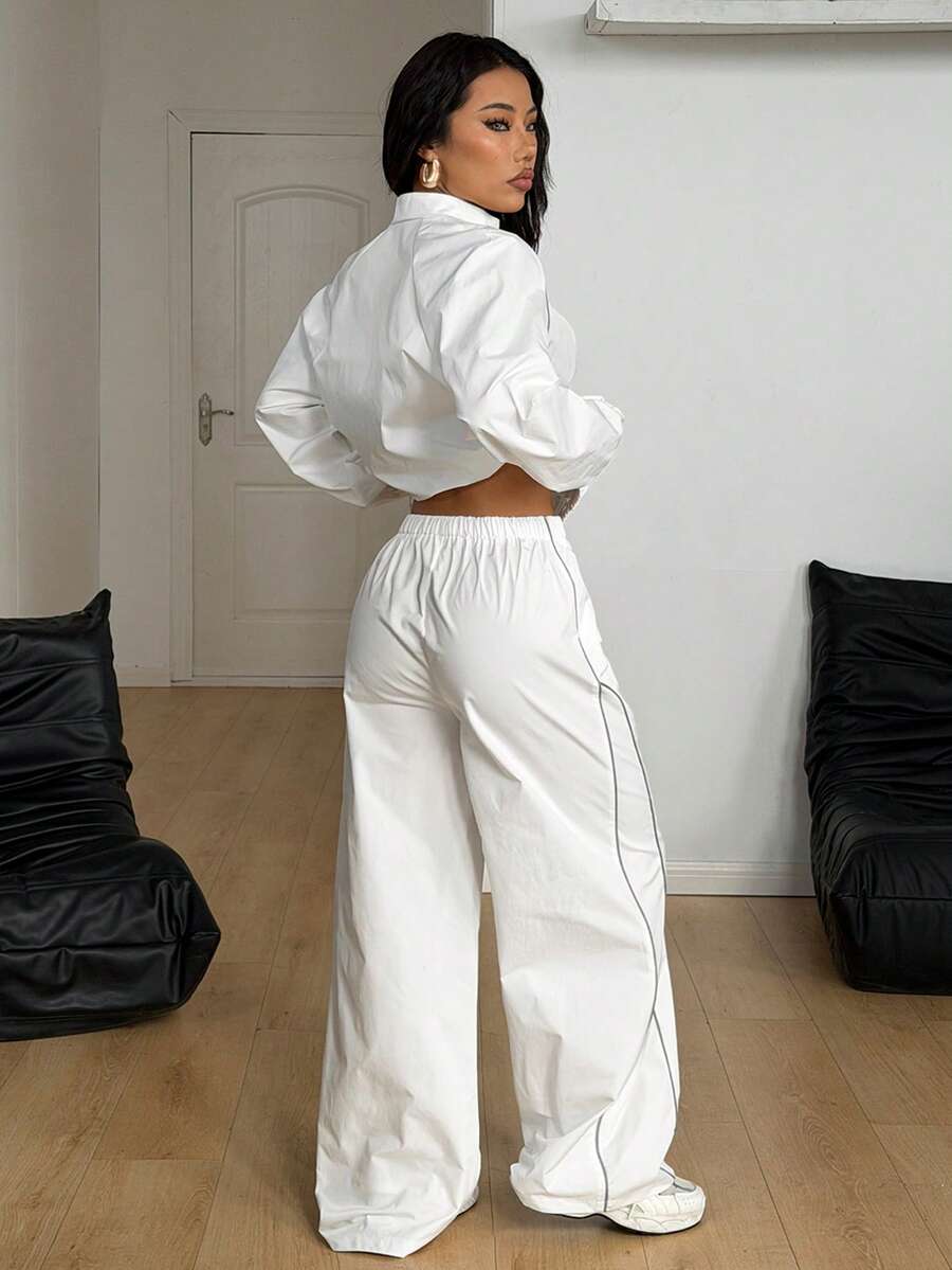 Women's two-piece sporty casual tracksuit set featuring a stand collar zip-up jacket with contrast binding and matching loose parachute pants.