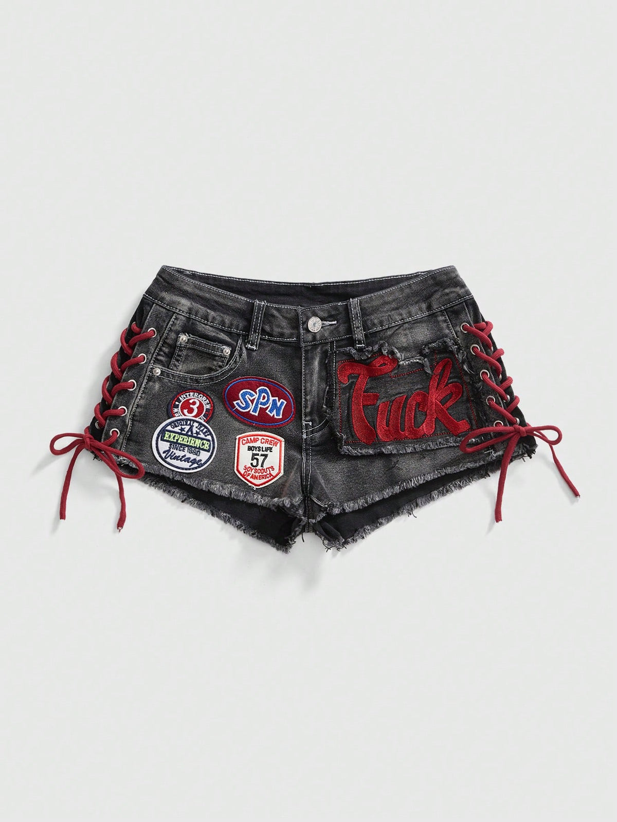 Women's Y2K low waist camo mini skort shorts featuring lace-up knot details, grommet eyelets, graphic lettering pattern, and a zipper fly.