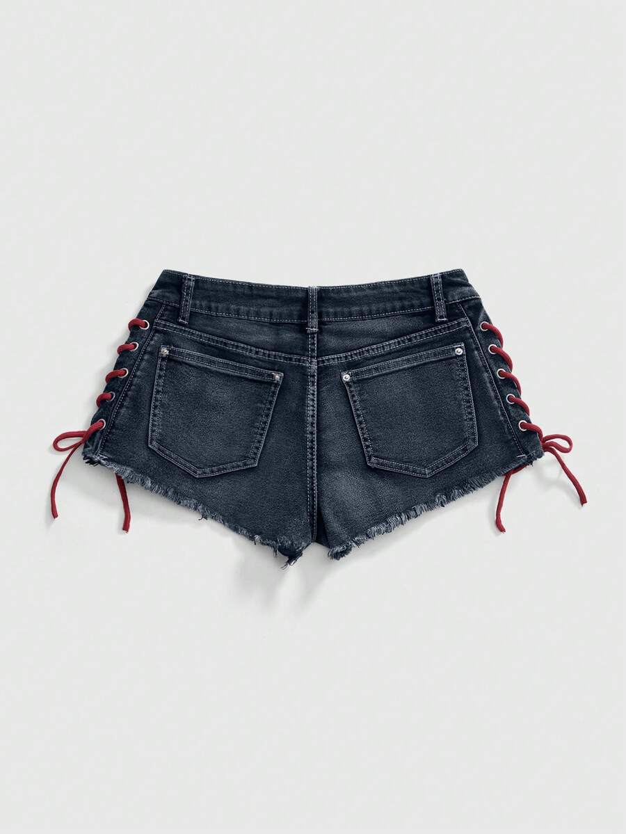 Women's Y2K low waist camo mini skort shorts featuring lace-up knot details, grommet eyelets, graphic lettering pattern, and a zipper fly.