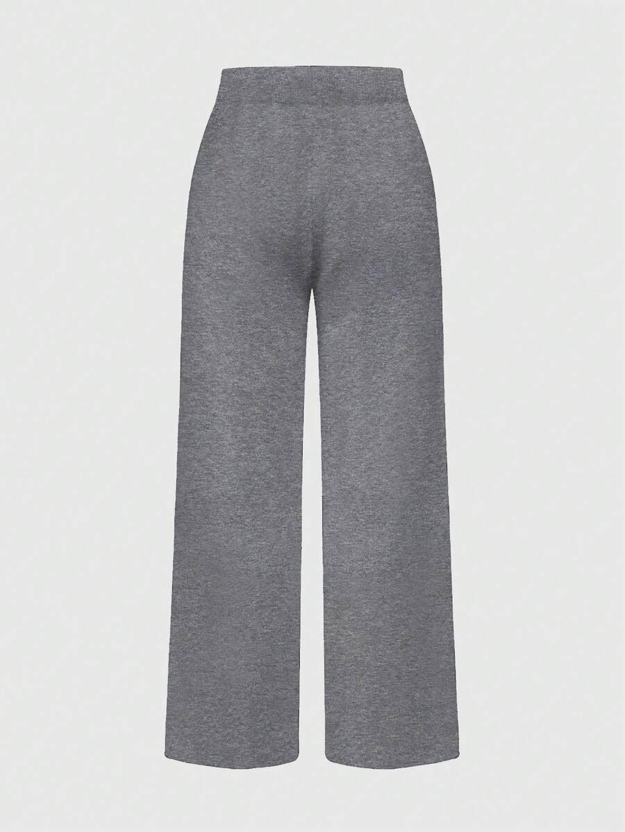 Women's two-piece rib-knit sweater set featuring a long-sleeve cold-shoulder crop top with strap details and matching wide-leg pants.