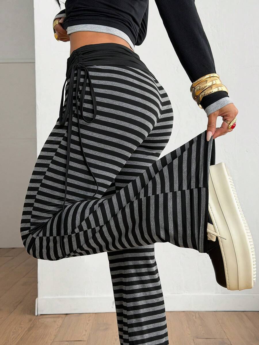 Women's striped flare leg pants featuring a mid-rise waist, slim fit thigh, and ruched side drawstring detail in stretch knit fabric.