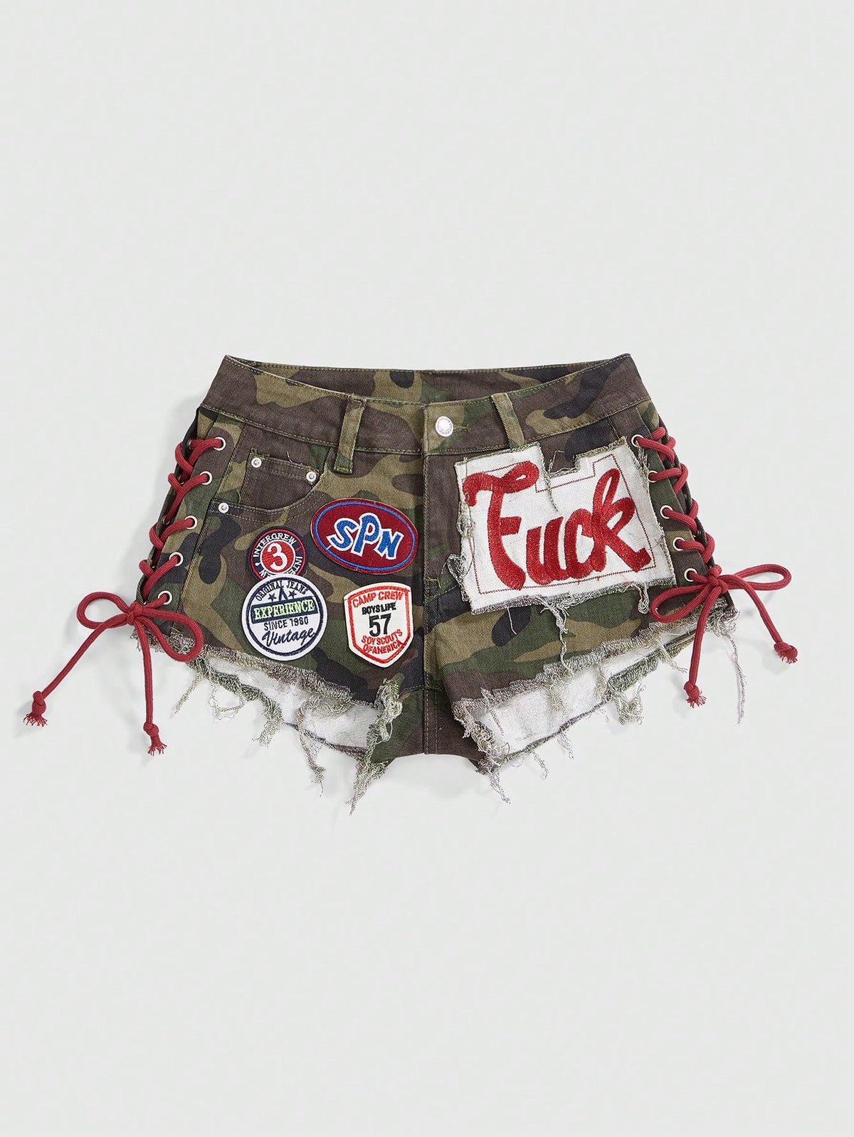 Women's Y2K low waist camo mini skort shorts featuring lace-up knot details, grommet eyelets, graphic lettering pattern, and a zipper fly.