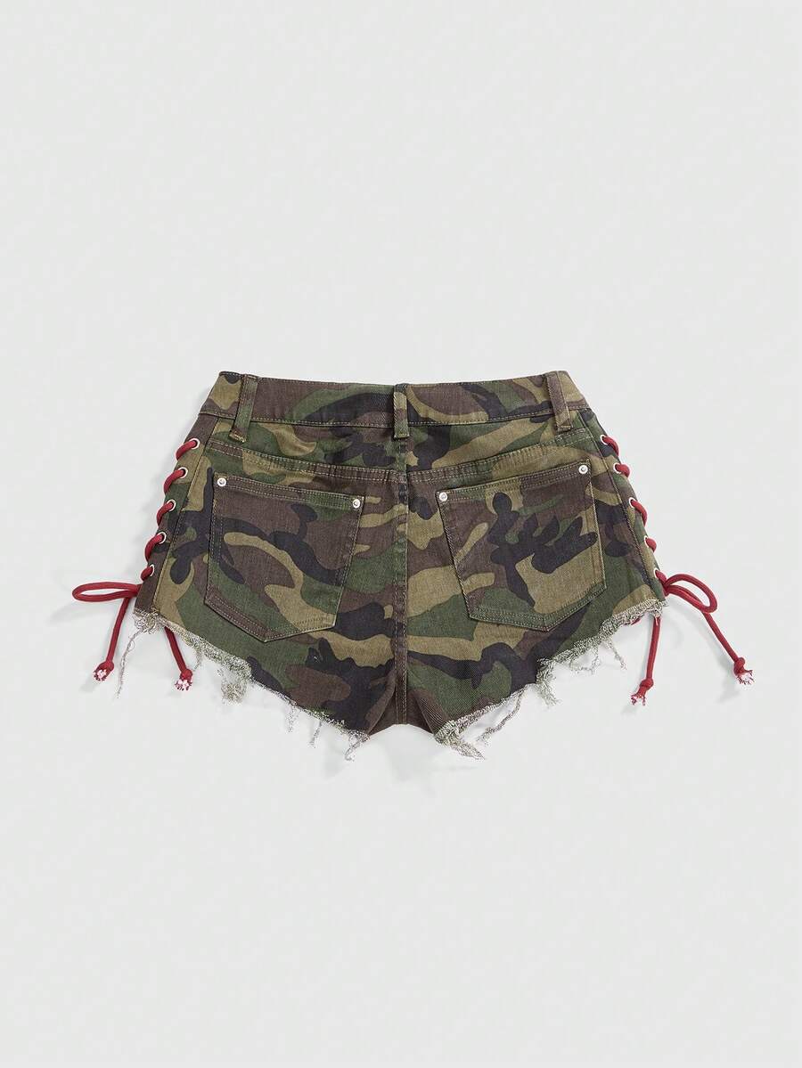 Women's Y2K low waist camo mini skort shorts featuring lace-up knot details, grommet eyelets, graphic lettering pattern, and a zipper fly.