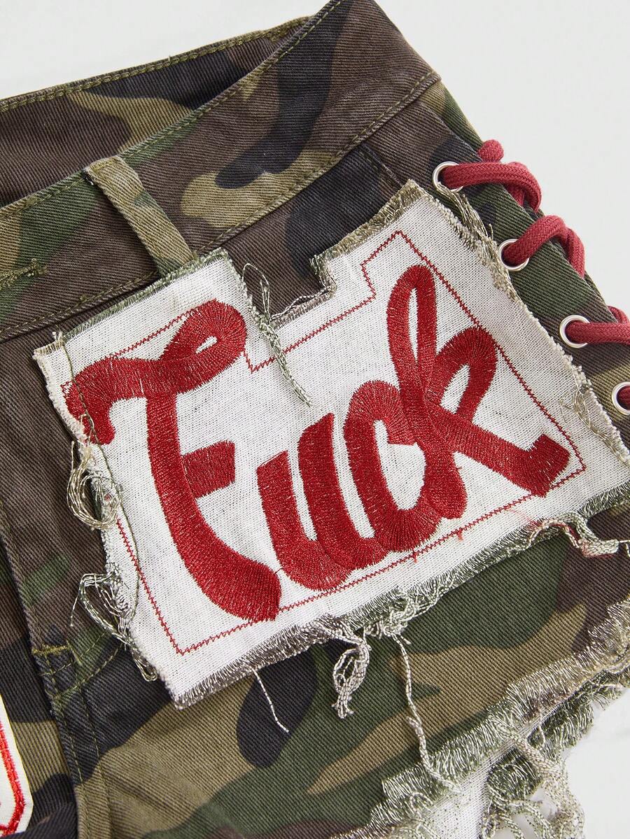 Women's Y2K low waist camo mini skort shorts featuring lace-up knot details, grommet eyelets, graphic lettering pattern, and a zipper fly.