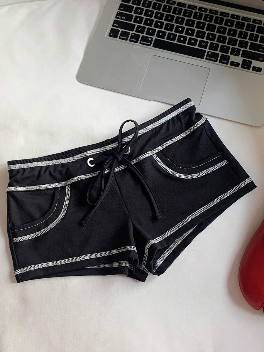 Women's low waist track shorts with drawstring waist, zipper detail, and mini length in a casual skinny fit