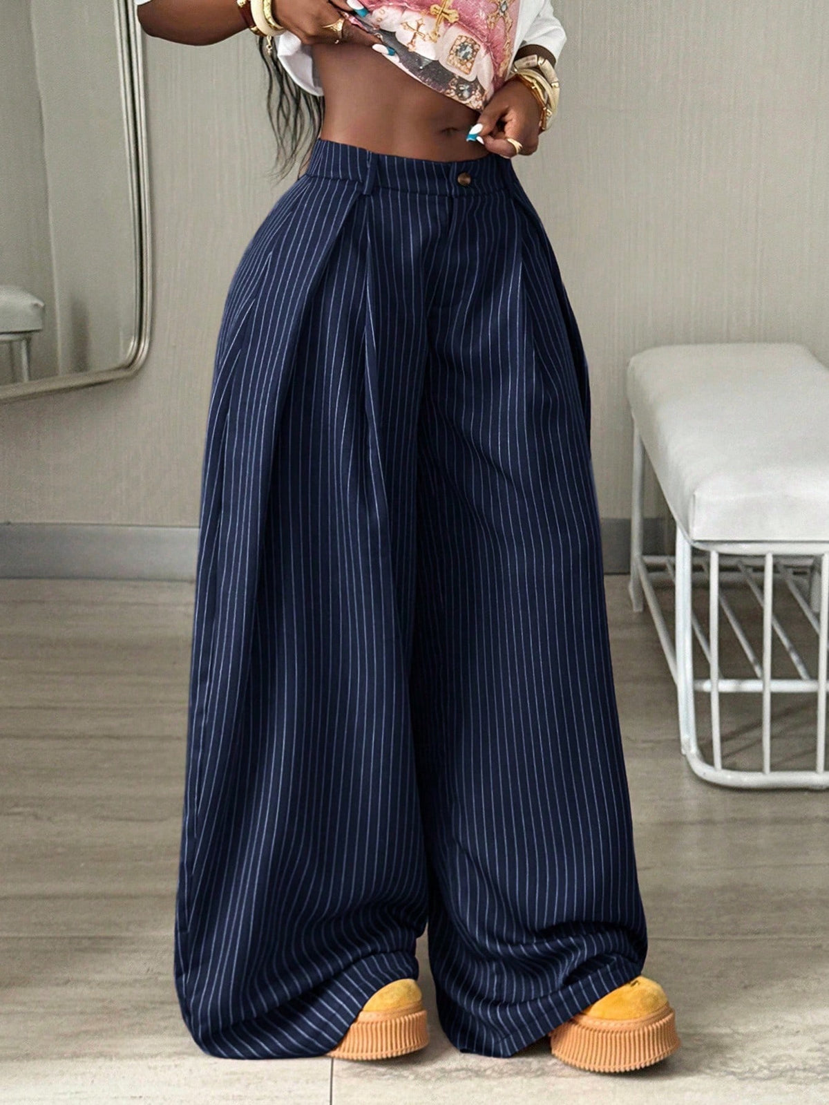 Women's brown striped wide leg pants with a low waist, curved hem, and loose casual fit in woven fabric.