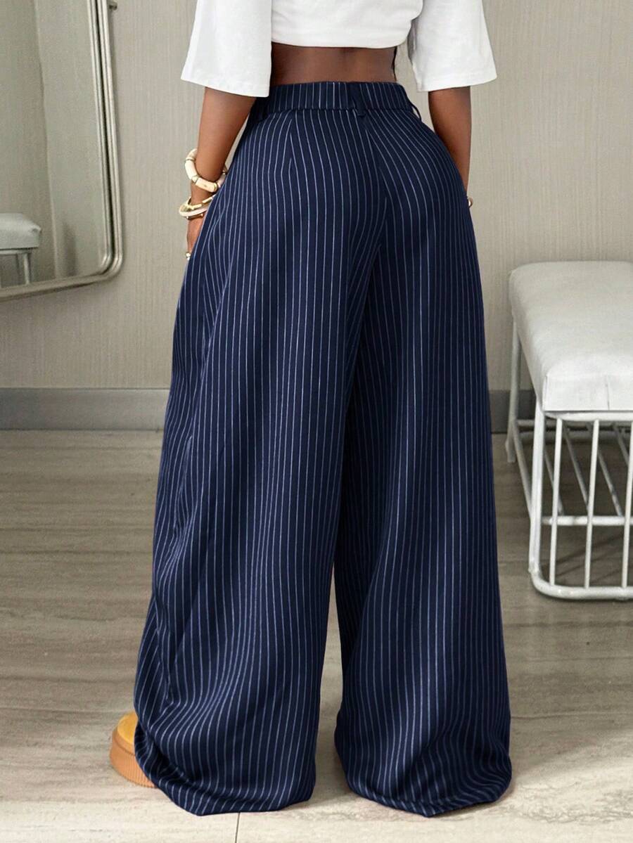 Women's brown striped wide leg pants with a low waist, curved hem, and loose casual fit in woven fabric.