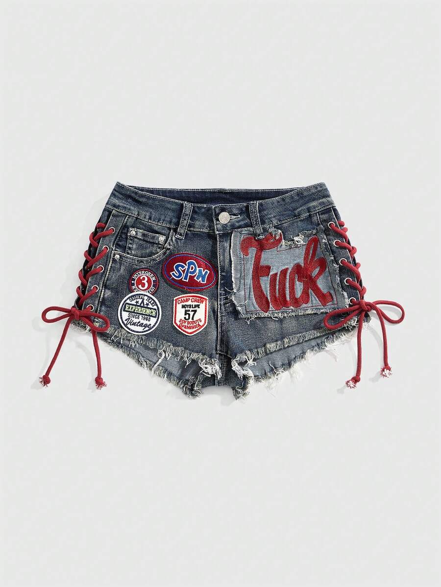 Women's Y2K low waist camo mini skort shorts featuring lace-up knot details, grommet eyelets, graphic lettering pattern, and a zipper fly.