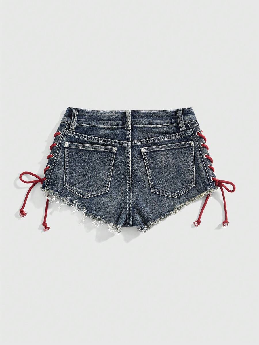 Women's Y2K low waist camo mini skort shorts featuring lace-up knot details, grommet eyelets, graphic lettering pattern, and a zipper fly.
